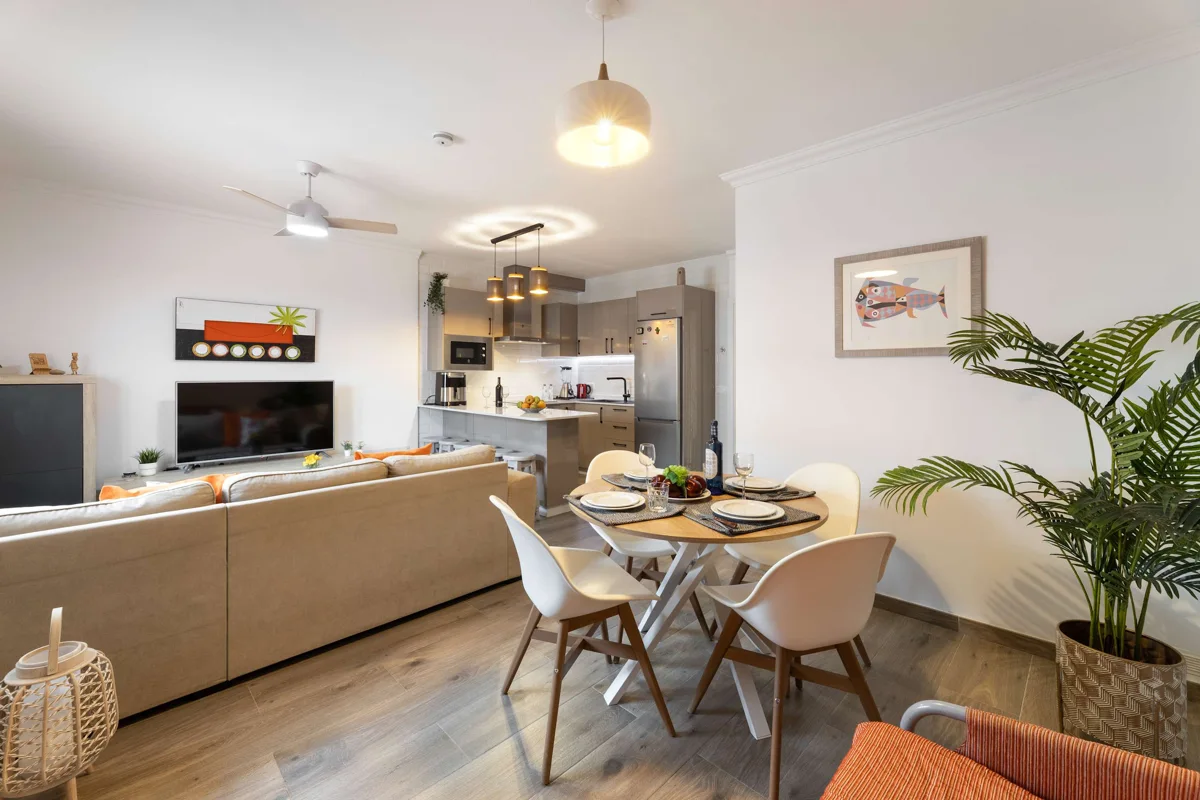 Helles Wohnzimmer mit Essbereich, Sofa und offener Küche